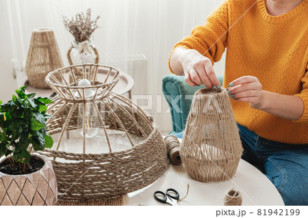 Woman makes handmade diy lamp from jute rope Woman makes handmade diy lamp from jute rope 81942199
