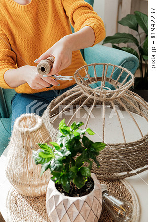 Woman makes handmade diy lamp from jute rope Woman makes handmade diy lamp from jute rope 81942237
