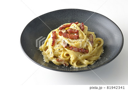 カリカリに焼いたベーコン入りフェットチーネのカルボナーラを白背景で撮影 81942341