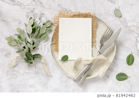 Blank paper card on a plate with eucalyptus branches and ribbons Blank paper card on a plate with eucalyptus branches and ribbons 81942462