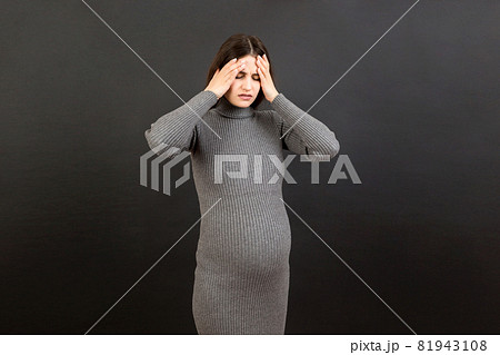 Beautiful young pregnant woman feeling head ache on colored background isolated. Stressed pregnant woman or mother problems Beautiful young pregnant woman feeling head ache on colored background isolated. Stressed pregnant woman or mother problems 81943108