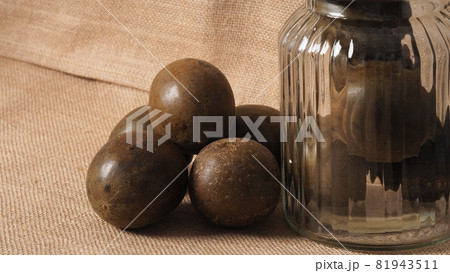 Monk fruit or Luo Han Guo. Dried fruits for healthy sweetener drink. Natural herbal remedy and glass bottle background. Monk fruit drink for who concern health and sugar substitute. 81943511