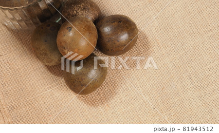 Monk fruit or Luo Han Guo. Dried fruits for healthy sweetener drink. Natural herbal remedy and glass bottle background. Monk fruit drink for who concern health and sugar substitute. 81943512