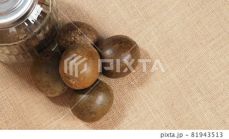 Monk fruit or Luo Han Guo. Dried fruits for healthy sweetener drink. Natural herbal remedy and glass bottle background. Monk fruit drink for who concern health and sugar substitute. 81943513
