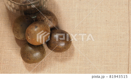 Monk fruit or Luo Han Guo. Dried fruits for healthy sweetener drink. Natural herbal remedy and glass bottle background. Monk fruit drink for who concern health and sugar substitute. 81943515