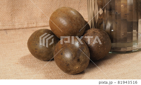 Monk fruit or Luo Han Guo. Dried fruits for healthy sweetener drink. Natural herbal remedy and glass bottle background. Monk fruit drink for who concern health and sugar substitute. 81943516