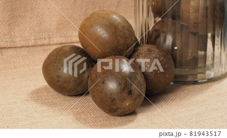 Monk fruit or Luo Han Guo. Dried fruits for healthy sweetener drink. Natural herbal remedy and glass bottle background. Monk fruit drink for who concern health and sugar substitute. 81943517