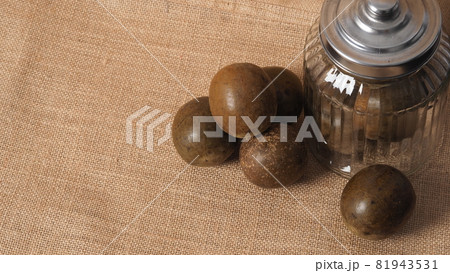 Monk fruit or Luo Han Guo. Dried fruits for healthy sweetener drink. Natural herbal remedy and glass bottle background. Monk fruit drink for who concern health and sugar substitute. 81943531