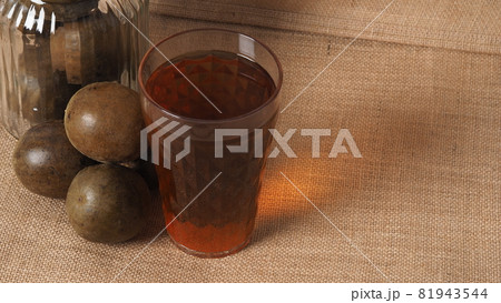 Monk fruit or Luo Han Guo. Dried fruits for healthy sweetener drink. Natural herbal remedy and glass bottle background. Monk fruit drink for who concern health and sugar substitute. 81943544