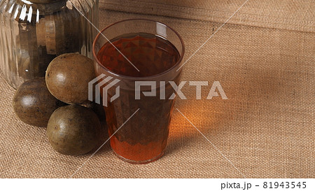 Monk fruit or Luo Han Guo. Dried fruits for healthy sweetener drink. Natural herbal remedy and glass bottle background. Monk fruit drink for who concern health and sugar substitute. 81943545