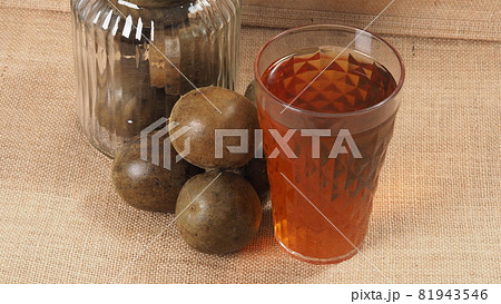 Monk fruit or Luo Han Guo. Dried fruits for healthy sweetener drink. Natural herbal remedy and glass bottle background. Monk fruit drink for who concern health and sugar substitute. 81943546
