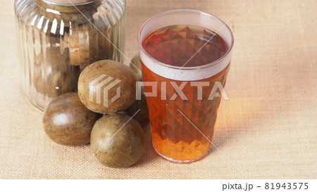Monk fruit or Luo Han Guo. Dried fruits for healthy sweetener drink. Natural herbal remedy and glass bottle background. Monk fruit drink for who concern health and sugar substitute. 81943575