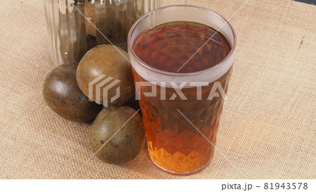 Monk fruit or Luo Han Guo. Dried fruits for healthy sweetener drink. Natural herbal remedy and glass bottle background. Monk fruit drink for who concern health and sugar substitute. 81943578