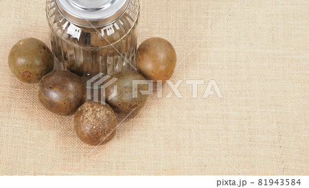 Monk fruit or Luo Han Guo. Dried fruits for healthy sweetener drink. Natural herbal remedy and glass bottle background. Monk fruit drink for who concern health and sugar substitute. 81943584
