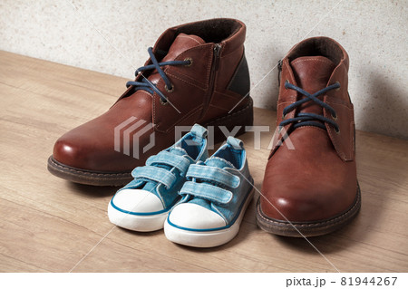 Men's and children's shoes on a wooden floo Men's and children's shoes on a wooden floo 81944267
