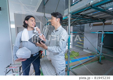 建築現場でタブレットを見ながら会話する現場監督と大工さん2人 建築現場でタブレットを見ながら会話する現場監督と大工さん2人 81945230