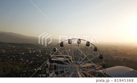 Ferris wheel on the green hill Kok Tobe at sunset Ferris wheel on the green hill Kok Tobe at sunset 81945368