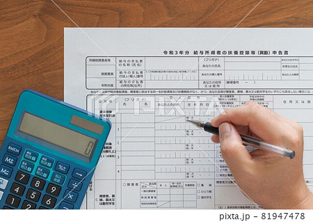給与所得の扶養控除等申告書 年末調整書類（電卓とペン、記入） 81947478
