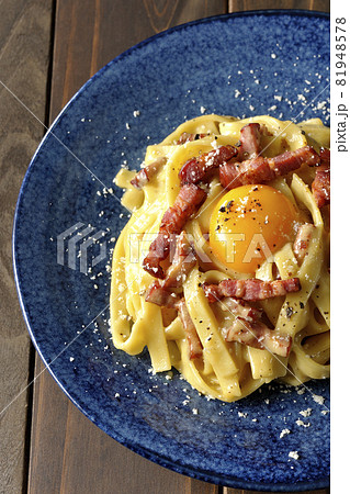 卵黄やカリカリに焼いたベーコンが入っているフェットチーネのカルボナーラを俯瞰で撮影 81948578