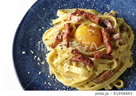 卵黄やカリカリに焼いたベーコンが入っているフェットチーネのカルボナーラを白背景で俯瞰撮影 卵黄やカリカリに焼いたベーコンが入っているフェットチーネのカルボナーラを白背景で俯瞰撮影 81948865