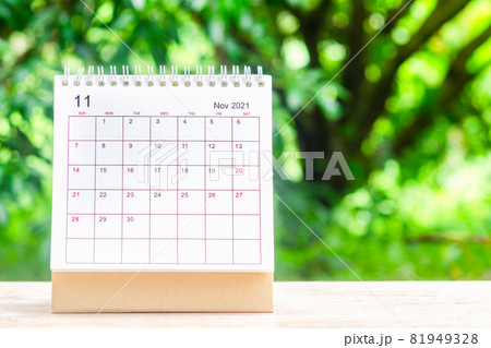 November month, Calendar desk 2021 for organizer to planning and reminder on wooden table with green nature background. 81949328