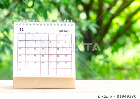 October month, Calendar desk 2021 for organizer to planning and reminder on wooden table with green nature background. 81949330
