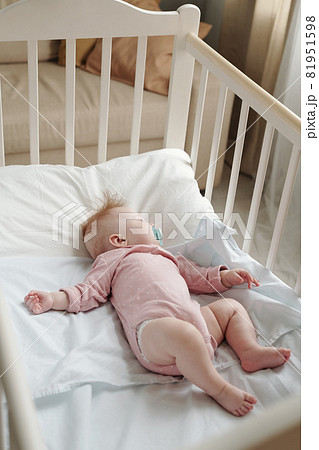 Adorable baby girl with pacifier in mouth sleeping in cradle Adorable baby girl with pacifier in mouth sleeping in cradle 81951598