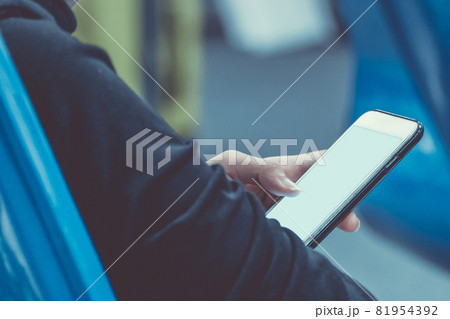 woman holding and using mobile smartphone to connect airport wifi internet to searching for information while waiting for flight at the airport terminal. communication and technology concept. 81954392