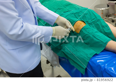 Doctor wear white gown, Inject anesthetic to patient's knee for prepare surgery. Doctor wear white gown, Inject anesthetic to patient's knee for prepare surgery. 81956922