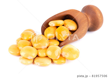 Pickled yellow lupine beans in wooden scoop, isolated on white background. Tournus, preserved lupinus. 81957506
