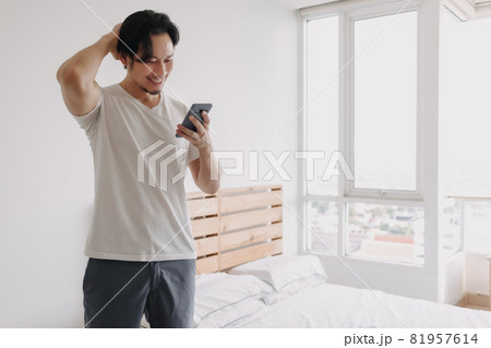 Happy man greeting online friends in the smartphone. Happy man greeting online friends in the smartphone. 81957614