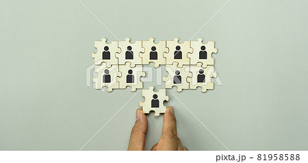 Top view of human resources and recruiting business or team leader concepts. Hand adult Asian man holding of people icon community on wooden cube block. Object on grey paper background. Banner border. Top view of human resources and recruiting business or team leader concepts. Hand adult Asian man holding of people icon community on wooden cube block. Object on grey paper background. Banner border. 81958588