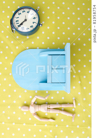 Small toy furniture. Wooden human mannequin figure with classic alarm clock. 81958754