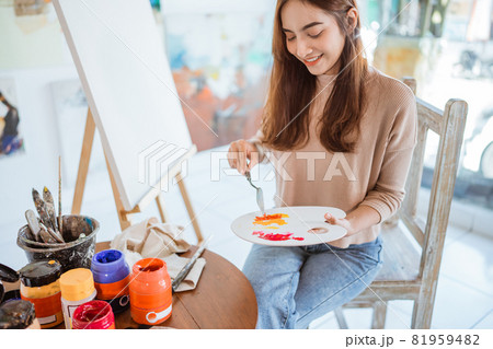 asian female artist painting on canvas doing some art projects on her studio workshop 81959482