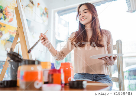 asian female artist painting on canvas doing art projects on her studio 81959483