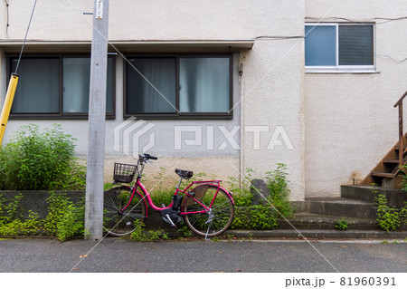 下町の古いアパートの横に置かれた赤い自転車 下町の古いアパートの横に置かれた赤い自転車 81960391
