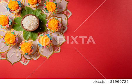 Happy Dussehra. Yellow flowers, green leaf and rice on red background. Dussehra Indian Festival concept. Happy Dussehra. Yellow flowers, green leaf and rice on red background. Dussehra Indian Festival concept. 81960722
