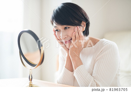 鏡でスキンケアをする上品なミセス女性 81963705