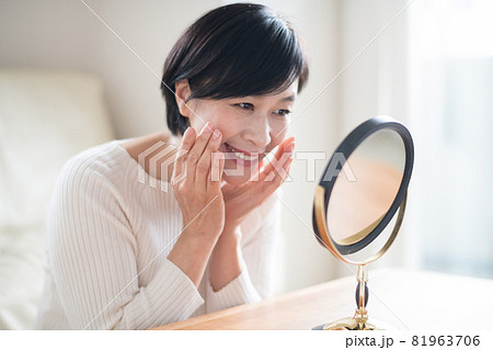 鏡でスキンケアをする上品なミセス女性 81963706