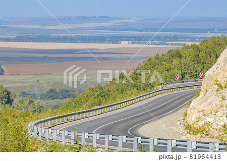 the winding highway with sharp turns and slopes, with warning road signs is located high in the mountains the winding highway with sharp turns and slopes, with warning road signs is located high in the mountains 81964413
