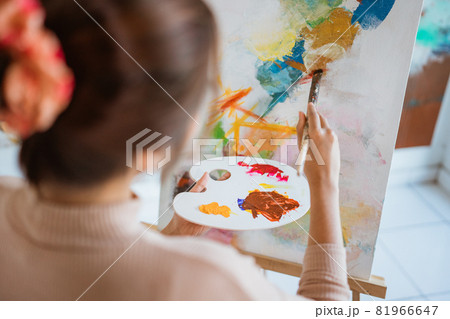 painter artist painting on canvas shoot from her back 81966647