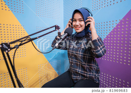 A vlogger girl is recording a podcast in studio 81969683