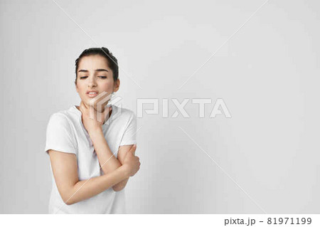 woman in a white t-shirt pain in the neck health problems 81971199