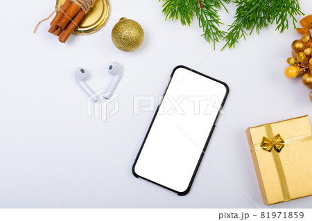 Composition of smartphone with copy space, wireless earphones and christmas decorations on white 81971859