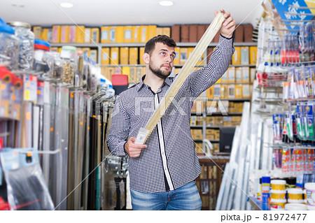Guy deciding on best molding in houseware store Guy deciding on best molding in houseware store 81972477