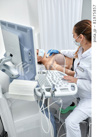 woman getting ultrasound of a thyroid from doctor woman getting ultrasound of a thyroid from doctor 81975857