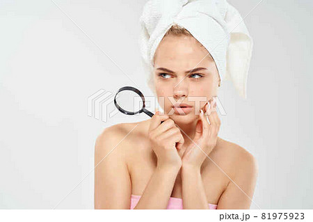 woman with bare shoulders with a magnifying glass in her hands black dots on her face woman with bare shoulders with a magnifying glass in her hands black dots on her face 81975923