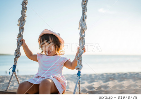 happy Little girl swinging at the beach happy Little girl swinging at the beach 81978778