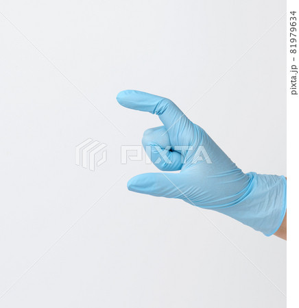 Doctor's hand in a blue medical glove holds an object on a white background. Copy space, hold any object Doctor's hand in a blue medical glove holds an object on a white background. Copy space, hold any object 81979634