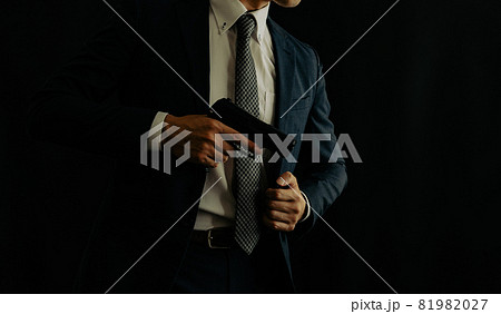 拳銃を構えるスーツの人物 拳銃を構えるスーツの人物 81982027